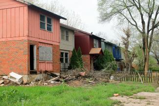 Street view of residential property and yard in a dilapidated state